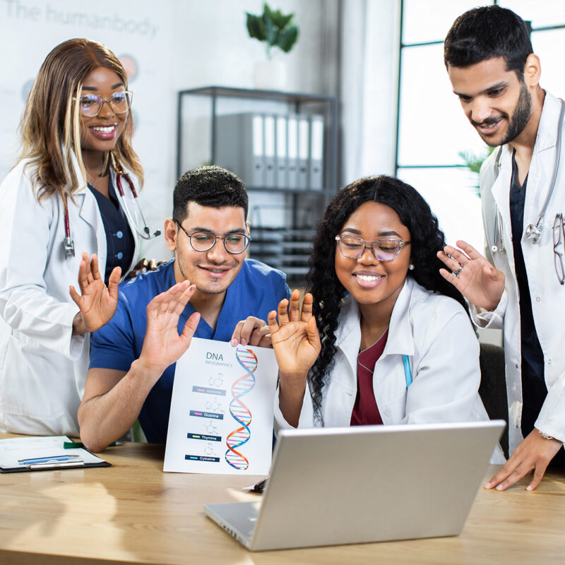 multiracial genetics doctors scientists in uniforms waving to their colleague during video call Four diverse multiracial genetics doctors scientists in uniforms waving to their colleague during video online conference, while working over joint research of structural DNA formula and drugs